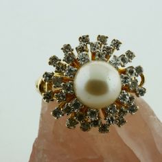 14K Yellow gold Large White Pearl and 1.2ct estimate Diamond Halo Ring, 8mm pearl center, 3 rows of tiered diamonds G color SI1 clarity, .75 inch across, sits 5/8 inch off finger, open work half shank, split shank, Ring size 6, Circa 1970, 10.5 grams Stock # BB258R11 This listing contains photographs of the actual item you will receive. Our items are in excellent condition with little or no signs of wear and many are one of a kind pre-owned estate finds. Please look closely at the pictures in th Gold Heirloom Pearl Ring With Halo Setting, Luxury Pearl Ring With Halo Design, 14k Gold Pearl Ring With Halo Setting, Luxury Gold Pearl Ring With Halo, Luxury White Pearl Ring With Halo Setting, White Band, Halo Diamond Ring, Fine Jewelry Designers, Halo Rings