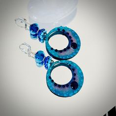 "These big colorful hoop earrings are comprised of enameled hoop charms 38mm across by 43mm in length.  These amazing hoops are done in dark and light blue colors with light blue and dark blue\" bubbles\" by glass artist Carolyn. These colorful hoops dangle below 11mm artisan Lampwork glass beads done in a light transparent blue with etched circles. The earrings are accented with ceramic light and dark blue bead caps, Hill Tribe Silver beads and suspend from sterling silver lever back ear wires. The total length is 3 1/4\". These are beautiful, eye-catching earrings! Make a wonderful gift too! Comes in a pretty gift box with fast shipping." Handmade Blue Hoop Jewelry, Blue Hoop Earrings With Ear Wire, Handmade Blue Round Hoop Earrings, Blue Beaded Small Hoop Earrings, Blue Small Hoop Jewelry, Blue Small Hoop Earrings, Blue Small Hoop Earrings With Matching Set, Blue Small Hoop Earrings For Pierced Ears, Blue Beaded Round Hoop Earrings