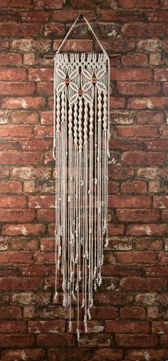 a white macrame hanging on a brick wall