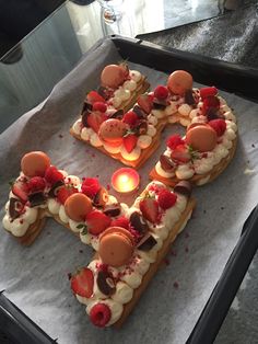 a number shaped cake sitting on top of a pan covered in frosting and strawberries