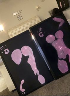 two black and pink art pieces with hand prints on them in the shape of baby footprints