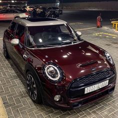 a maroon mini cooper parked in a parking lot