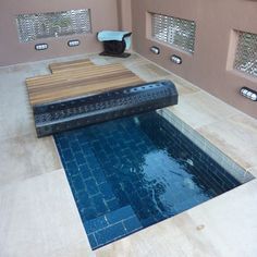 an indoor swimming pool in the middle of a tiled floor