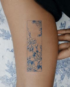 a woman with a tattoo on her arm has a blue and white flowered design