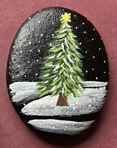 a painted rock with a christmas tree on it