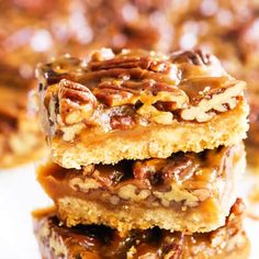 three pieces of pecan bar stacked on top of each other with nuts and caramel toppings