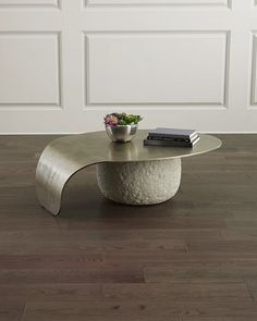 a coffee table with a plant on top of it in front of a white wall