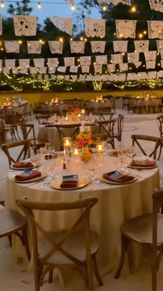 the tables are set with candles and place settings for an outdoor dinner or party event