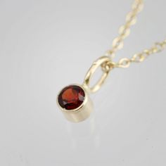 Very classy, simple, and dainty. This handcrafted gold pendant has a natural Garnet stone and comes on your choice of a 16 or an 18 inch gold chain with the artist's tag attached to the clasp. It can also be paired with other pendants! Mix and match to create your own personalized necklace or mother necklace! Gold is 14ky. Stone measures 3mm in diameter. Birthstone for January. All Laine Benthall jewelry comes with a lifetime warranty. This pendant can also be purchased without the chain, just g 14k Gold Necklace With Bail For Gift, Mother Necklace, Mothers Necklace, Garnet Stone, Drop Necklace, Personalized Necklace, Necklace Gold, Gold Pendant, The Chain