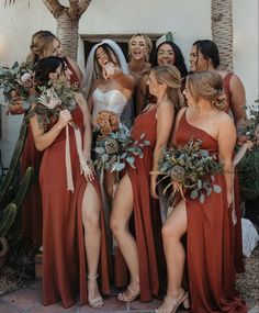 a group of women standing next to each other in front of a building with flowers