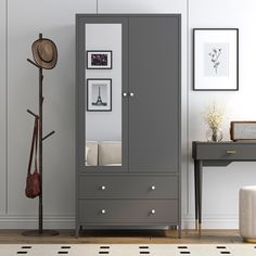 a grey armoire in a room with pictures on the wall and a coat rack