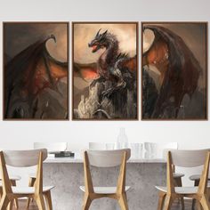 two paintings of a dragon sitting on top of a table in front of a white wall