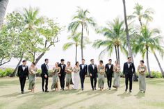 a group of people standing next to each other on top of a grass covered field