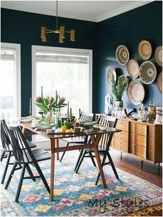 a dining room with blue walls and plates on the wall