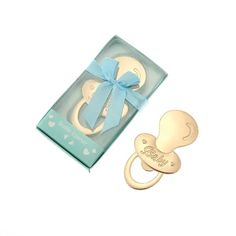 a baby pacifier in a gift box next to it's blue ribbon bow