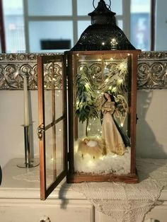 a lighted lantern with a bride and groom in it sitting on top of a table