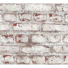 an old brick wall with white and red paint