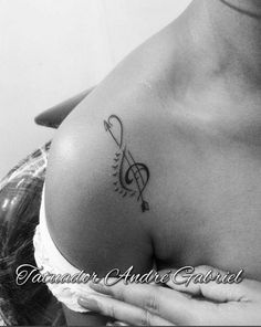 a black and white photo of a woman's shoulder with musical notes on it