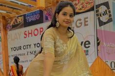 a woman in a yellow sari posing for the camera