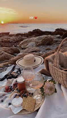 a picnic on the beach with wine, crackers and bread in front of the ocean