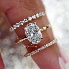 a woman's hand with three different rings and one diamond ring on her finger