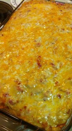 a cheesy casserole in a glass dish on top of the stove