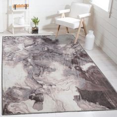 a white chair sitting next to a rug on top of a floor