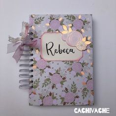 an open notebook with the word rebea written on it and a ribbon attached