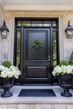 a black front door with two planters on either side