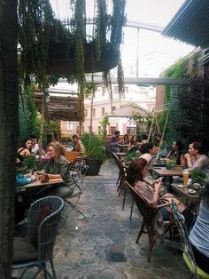 many people are sitting at tables outside eating