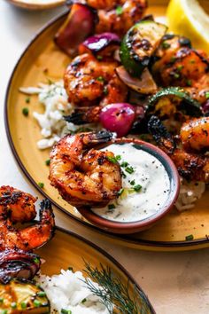 greek marinated grilled shrimp with lemon - dill sauce on a yellow plate