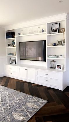 a living room with white bookcases and a flat screen tv