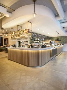 an empty bar with lots of bottles on the shelves and lights hanging from the ceiling