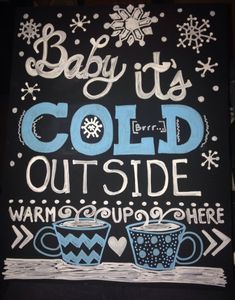 a sign that says baby it's cold outside and two cups of coffee are on the table