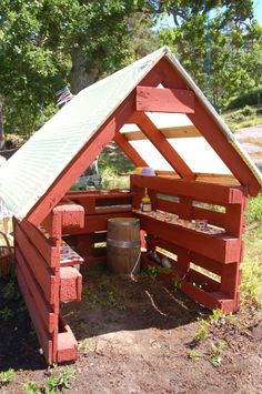 an outhouse made from wooden pallets with a metal roof