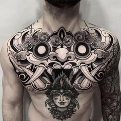 a man with tattoos on his chest and chest