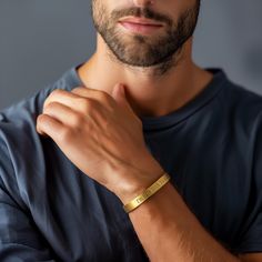 This 14k gold bracelet is a perfect blend of elegance and personalization, designed for men with a delicate yet sturdy open cuff style. The bracelet features an engraved text, allowing you to customize it with a meaningful message. Made from high-quality 14k gold, this personalized bracelet is an ideal gift for any occasion, offering a unique and timeless piece of jewelry. The adjustable cuff design ensures a comfortable fit for any wrist size, making it a versatile accessory. Whether as a perso Classic Gold Name Bracelet For Promise, Gold Bracelets With Engraving Option For Promise, Mens Engraved Bracelet, Gold Promise Bracelets With Engraving Option, Modern Customizable Gold Bracelets, Modern Customizable Gold Bracelet, Gold Cuff Bracelet With Engraving Option, Gold Bracelets For Anniversary On Father's Day, Gold Engraved Wristband For Gift