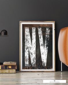 an old metal letter is displayed on the wall next to a chair and bookcase