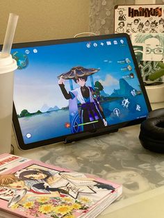 a laptop computer sitting on top of a desk next to a cup of coffee and headphones