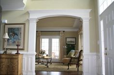 a living room filled with furniture next to a doorway