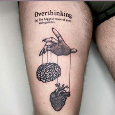 a man's leg with tattoos on it and the words overthiking hanging from them