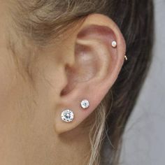 a close up of a person's ear with two diamond studs on it