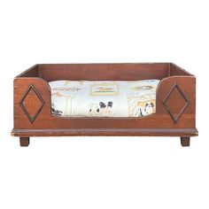 an old wooden dog bed with a pillow on it