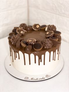 a white cake with chocolate and nuts on top