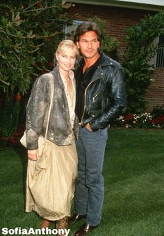 a man standing next to a woman on top of a lush green field