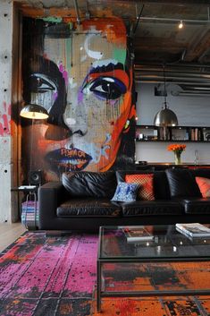 a living room filled with furniture and a painting on the wall next to a coffee table