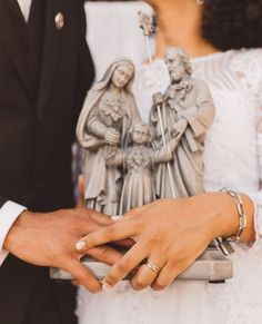 a bride and groom holding hands in front of a wedding cake topper with an image of jesus on it