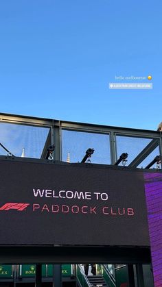 the welcome to paddock club sign is displayed on an outdoor building with stairs leading up to it