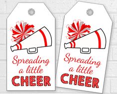 two red and white tags that say spreading a little cheer with a megaphone on them