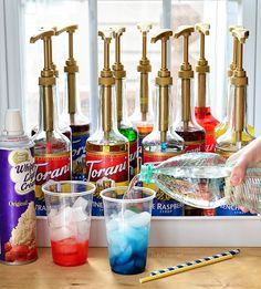 several different types of alcohol bottles on a table with pencils and glasses next to them